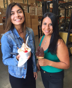a photograph of two happy NuFACE employees holding ice cream in a warehouse