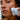 Close-up of a woman using a white and silver NoFace handheld facial cleansing device on her cheek.