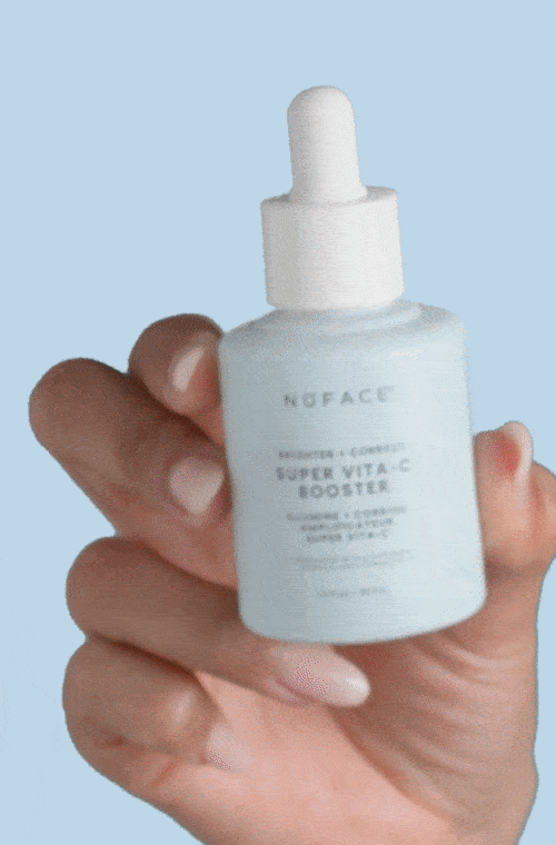 a photograph of a woman's hand holding the Super Vita-C Booster by NuFACE