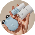 a photograph of a woman's hands holding the blue MINI+ Starter Kit by NuFACE