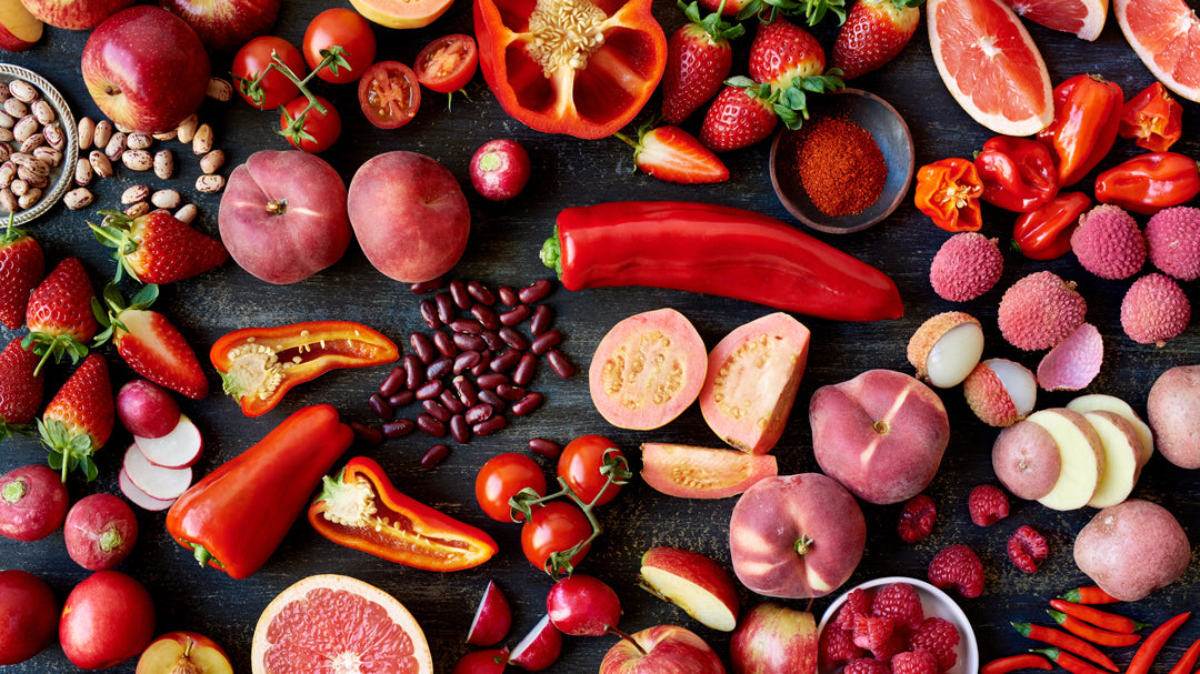 a photograph of an assortment of red vegetables and fruits
