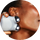 a photograph of a woman using the grey MINI+ device by NuFACE on her jawline